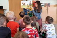 Dzieci w przedszkolu podczas zajęć z bibliotekarką.