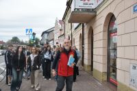 Młodzież na spacerze po łowickich ulicach z lokalnym przewodnikiem.