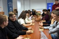 Młodzież biorąca udział w warsztatach plecionkarskich.