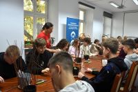 Młodzież biorąca udział w warsztatach plecionkarskich.