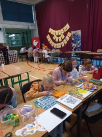 Uczestnicy Festiwalu Gier Planszowych i Komiksu przy stoisku biblioteki.