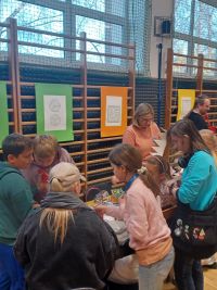 Uczestnicy Festiwalu Gier Planszowych i Komiksu przy stoisku biblioteki.