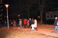 Grupa osób idzie po parku nocą.