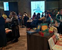 Ludzie między niskimi regałami z książkami dla dzieci