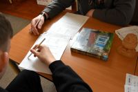 Zbliżenie na dłonie dwóch chłopców, którzy wypełniają karty pracy