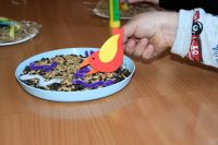 Zbliżenie na dziecięcą rękę trzymającą papierowego ptaszka.