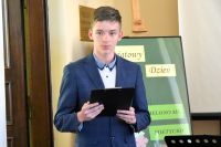 Młody chłopak czyta wiersz z kartki