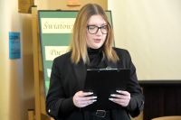 Młoda dziewczyna czyta wiersz z kartki