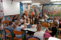 Grupa dzieci przy stolikach w sali lekcyjnej