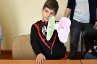 Chłopiec trzyma w ręku własnoręcznie wykonanego papierowego motyla.