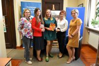 Grupa kobiet pozuje w bibliotece do zdjęcia.