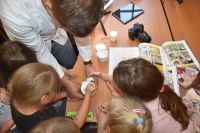 Na zdjęciach są przedszkolaki oraz przedstawiciele różnych zawodów, którzy brali udział w akcji Żywa Biblioteka.
