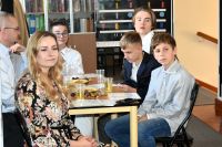 Seniorzy oraz młodzież biorąca udział w spotkaniu poetyckim.