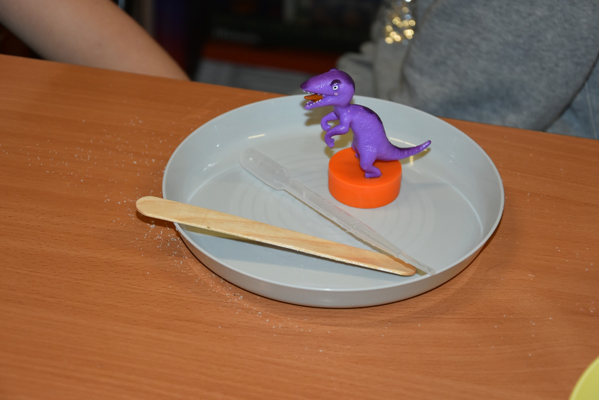 Plastikowa figurka dinozaura na talerzyku.