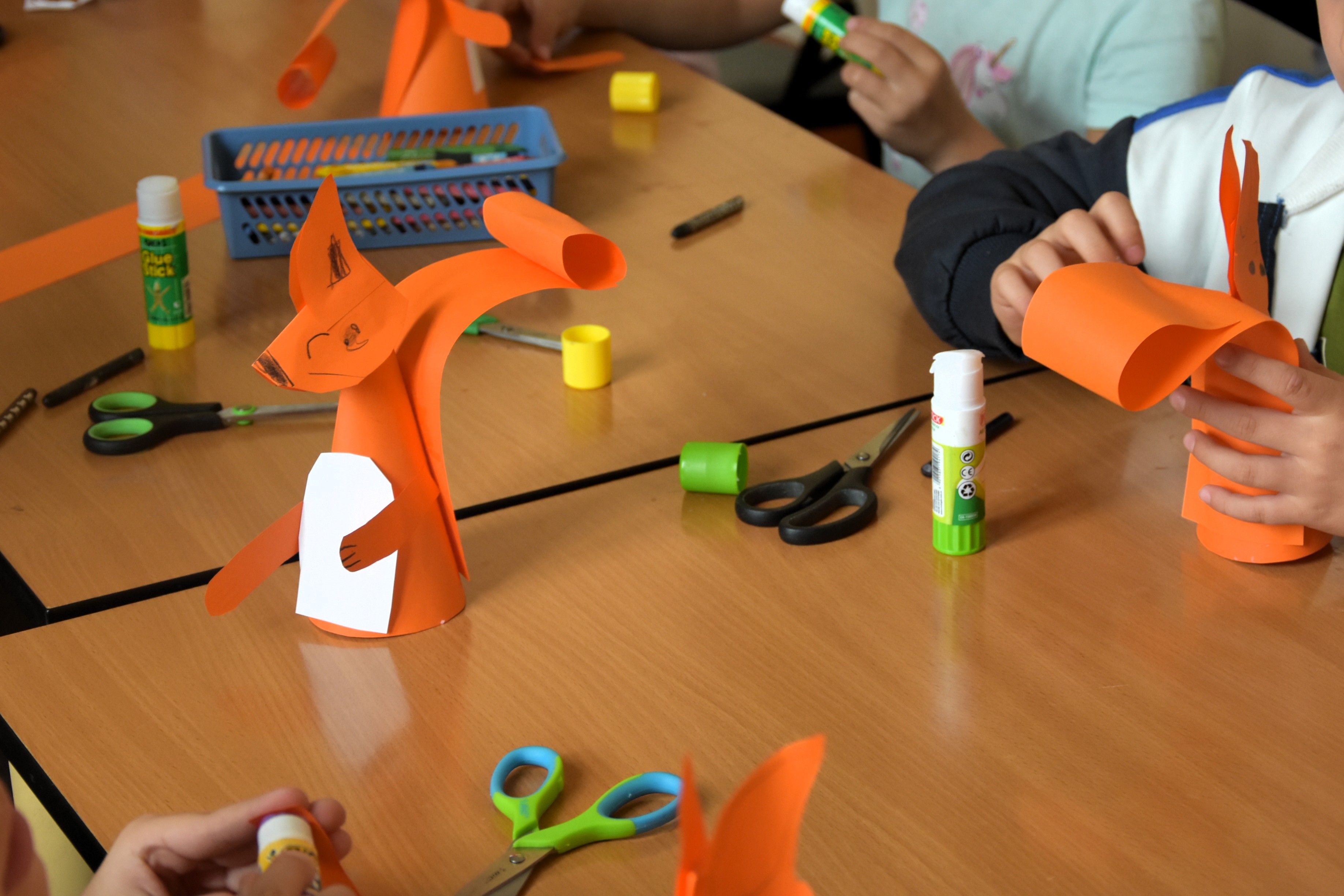 Papierowe wiewiórki i materiały plastyczne na stolikach