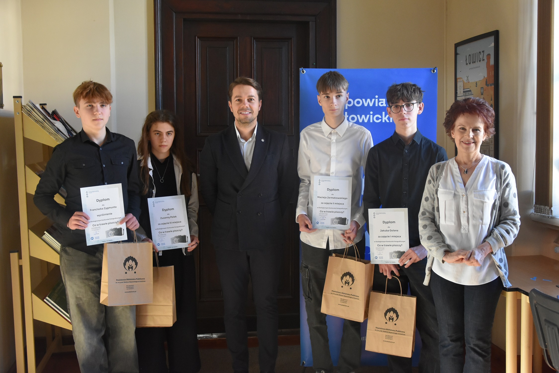 Laureaci Ekologicznego Konkursu Fotograficznego podczas wręczania nagród w bibliotece.