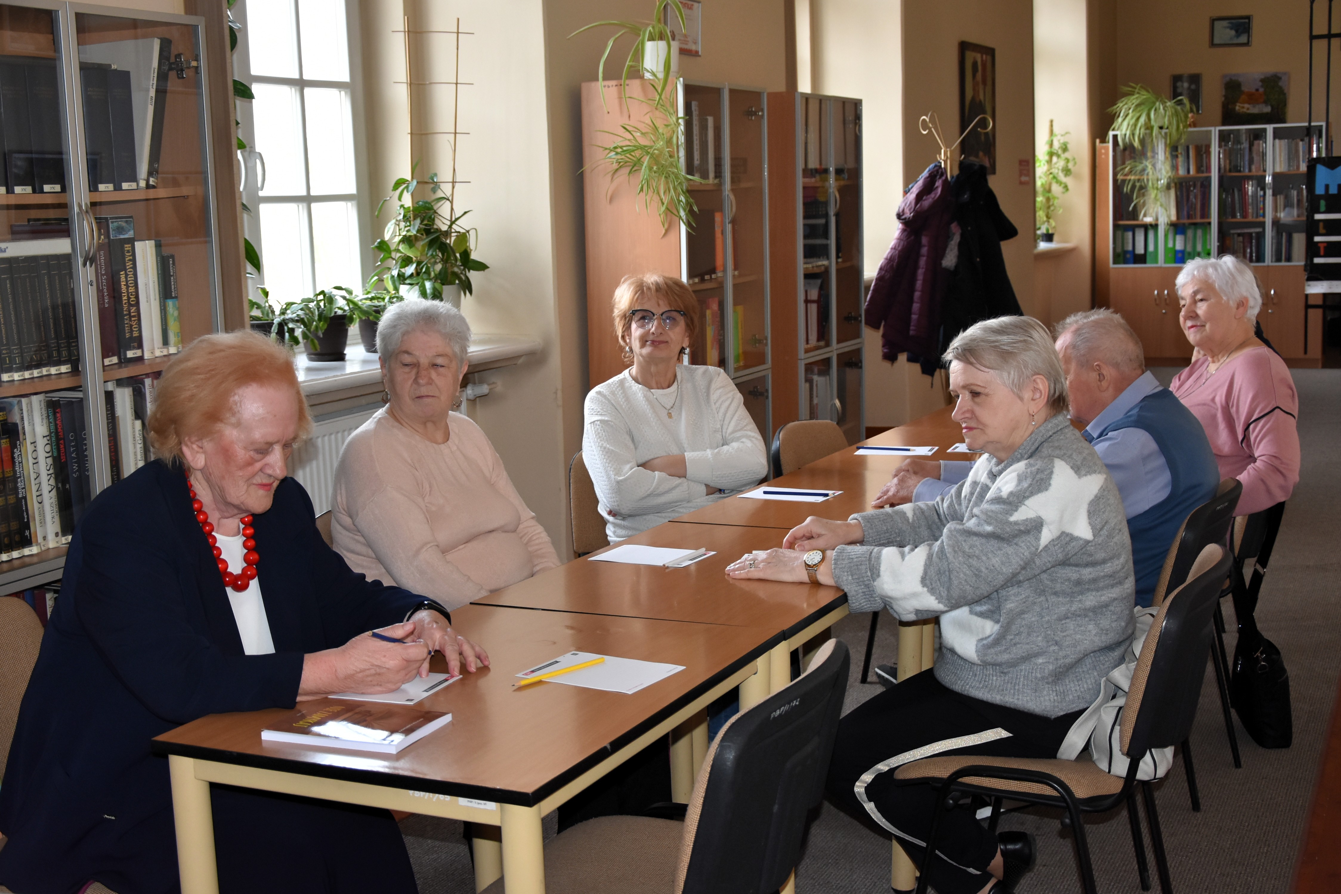 Grupa seniorów w bibliotece w czasie zajęć z cyklu KULTURYstyka UMYSŁOWA